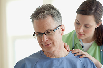 Nurse checking mole on man's neck