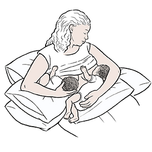 Mujer amamantando a gemelos.